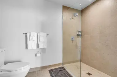a bathroom with a toilet and a glass shower at Corner Chic 2 Bedroom Downtown with Rooftop Pool & Views in Miami