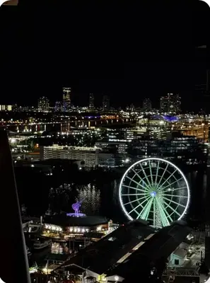 a view of a city at night with a ferris wheel at Luxxe Suite Downtown Brickell in Miami