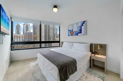 a bedroom with a white bed and a large window at Sleek Escape-Resort-Style Stay with Pool Spa & more in Miami