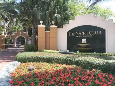 a sign for the xishi club in a park with flowers at The Yacht Club at Aventura Miami 3405 in South Island