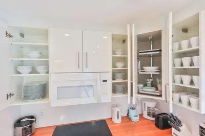 a kitchen with white cabinets and a microwave at Family Grand Advantage in Hollywood