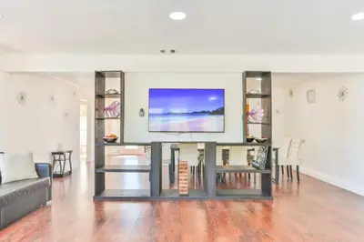 a living room with a couch and a tv on a wall at Oasis of Love and Joy Family in Miami