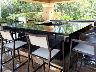 a black and white kitchen with a glass counter and chairs at The Yacht Club at Aventura Miami 6307 in South Island