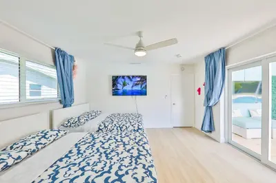 a bedroom with two beds and blue curtains at Family Poolside Palm Retreat with Jacuzzi in Hollywood