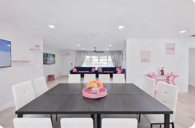 a dining room with a black table and white chairs at Family Poolside Palm Retreat with Jacuzzi in Hollywood