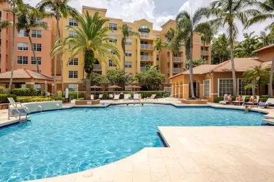 a pool at a resort with palm trees and buildings at The Yacht Club at Aventura Miami 9505 in South Island