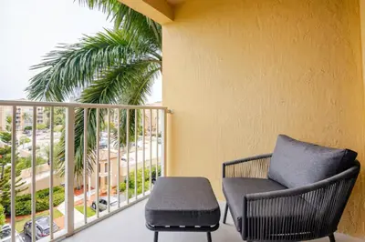 a chair sitting on a balcony with a palm tree at The Yacht Club at Aventura Miami 9505 in South Island