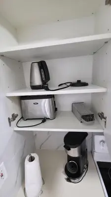 a kitchen with white shelves with appliances on it at Apartment close to shops & beach-Free Parking 109 in Hollywood