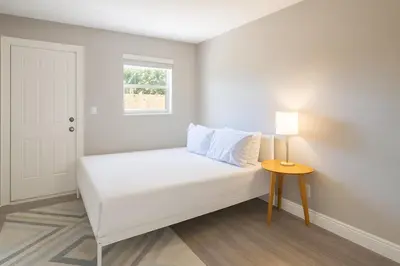 a small bedroom with a bed and a table at Modern 2BR Stay with Desk, Patio, BBQ, Free Parking in Fort Lauderdale
