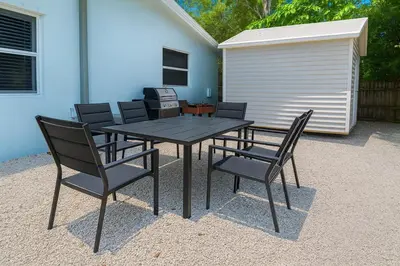 a black table and chairs and a building at Modern 2BR Stay with Desk, Patio, BBQ, Free Parking in Fort Lauderdale