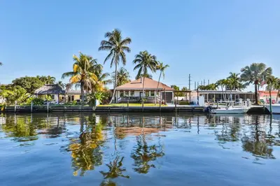 a house on a dock with boats in the water at 50 Shades of Grey on the Canal Villa STR-4500 in Fort Lauderdale