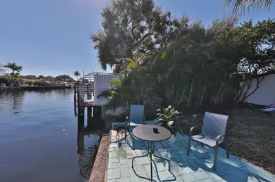 a table and two chairs sitting next to a body of water at 50 Shades of Grey on the Canal Villa STR-4500 in Fort Lauderdale
