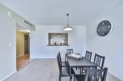 a dining room with a table and a clock on a wall at Dream Beach Room Free Parking - 02227 in Sunny Isles Beach