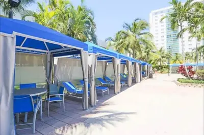 a row of blue tables and chairs on the beach at Dream Beach Room Free Parking - 02227 in Sunny Isles Beach