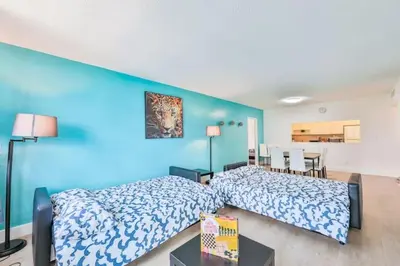 two beds in a room with a blue wall at Coastal Elegance Oasis in Sunny Isles STR-01308 in Sunny Isles Beach