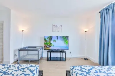 a room with two beds and a television in it at Coastal Elegance Oasis in Sunny Isles STR-01308 in Sunny Isles Beach