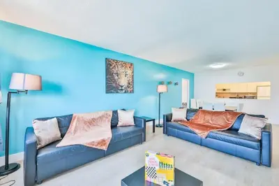 a living room with two couches and a blue wall at Coastal Elegance Oasis in Sunny Isles STR-01308 in Sunny Isles Beach