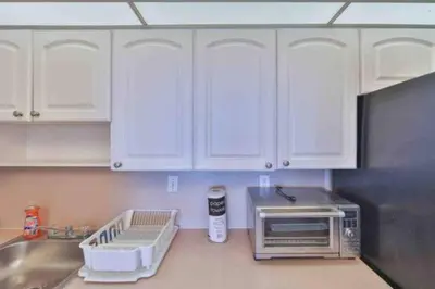 a kitchen with white cabinets and a microwave at Condo with Stunning View STR-01307 in Sunny Isles Beach