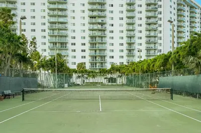 a tennis court in front of a large apartment building at Condo on the Beach-STR 01309 in Sunny Isles Beach