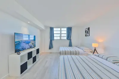 a bedroom with two beds and a flat screen tv at Ocean Vista in Sunny Isles Beach