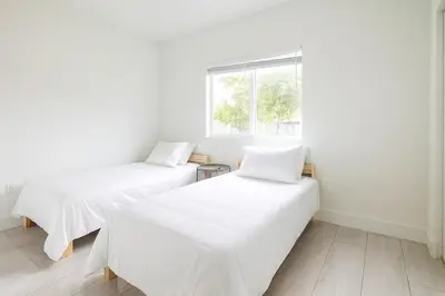 two beds in a white room with a window at 3BR Getaway, 4 Beds, Near Beach, Free Parking in Hallandale Beach