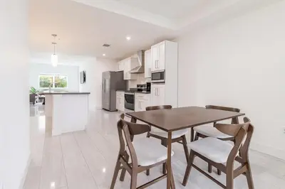 a kitchen and dining room with a table and chairs at 3BR Getaway, 4 Beds, Near Beach, Free Parking in Hallandale Beach