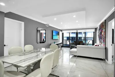 a dining room with a glass table and white chairs at Beachfront Luxury Alexander Unit, Pool Gym Parking in Miami Beach