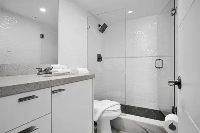 a bathroom with a toilet and a glass shower at Beachfront Luxury Alexander Unit, Pool Gym Parking in Miami Beach