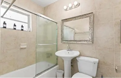 a bathroom with a sink and a toilet and a mirror at Private King Master Suite Near Hardrock Stadium in Miami Gardens