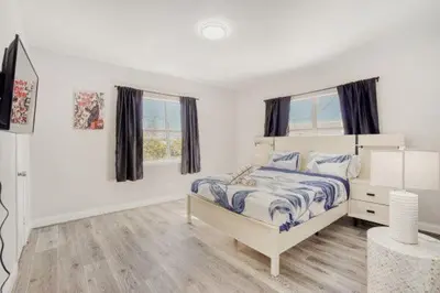 a white bedroom with a bed and two windows at Lauderdale Breeze Villas - Coastal 2 Bedroom in Fort Lauderdale