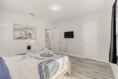 a white bedroom with a bed and a tv at Lauderdale Breeze Villas - Coastal 2 Bedroom in Fort Lauderdale