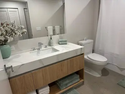 a bathroom with a sink and a toilet and a mirror at Sophisticated 2BR2BA at Miami World Center in Miami