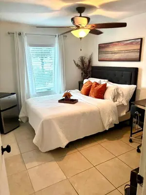 a bedroom with a large bed with a ceiling fan at Exclusive suites in Fort Lauderdale
