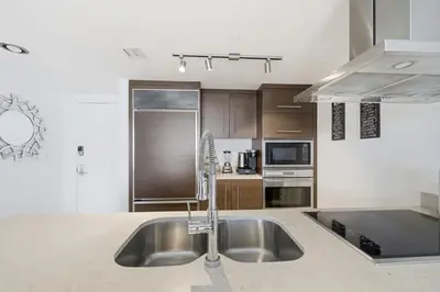 a kitchen with a sink and a stove top oven at Luxury Brickell Condo with Skyline & Bay Views in Miami
