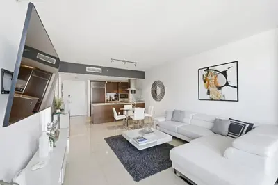 a white living room with a white couch and a table at Luxury Brickell Condo with Skyline & Bay Views in Miami