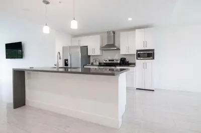 a kitchen with white cabinets and a counter top at Modern 3BR Getaway 4 Beds with Free Parking Included in Hallandale Beach