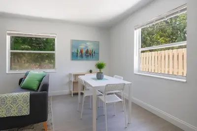 a living room with a table and a couch at Comfy 2BR Apartment Near Las Olas with Patio, BBQ and FREE PARKING in Fort Lauderdale