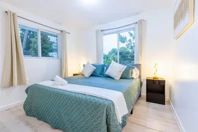 a bedroom with a bed and two windows at Riverside Retreat Skyline Views & Beach Nearby in Miami