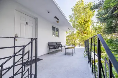 a balcony with a white door and a table at Riverside Retreat Skyline Views & Beach Nearby in Miami