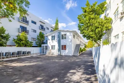 a house in a parking lot in front of a building at Riverside Retreat Skyline Views & Beach Nearby in Miami