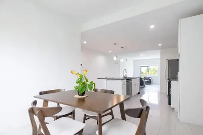 a kitchen and dining room with a wooden table and chairs at Comfortable 3BR Apartment, 4 Beds, Free Parking Included in Hallandale Beach