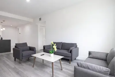 a living room with two couches and a table at Comfortable 3BR Apartment, 4 Beds, Free Parking Included in Hallandale Beach