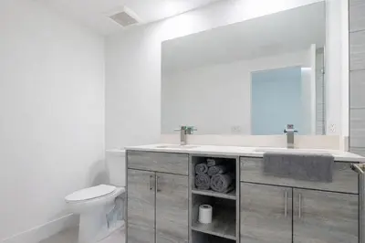 a bathroom with a sink and a toilet and a mirror at Comfortable 3BR Apartment, 4 Beds, Free Parking Included in Hallandale Beach