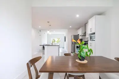 a kitchen and dining room with a wooden table and chairs at Comfortable 3BR Apartment, 4 Beds, Free Parking Included in Hallandale Beach