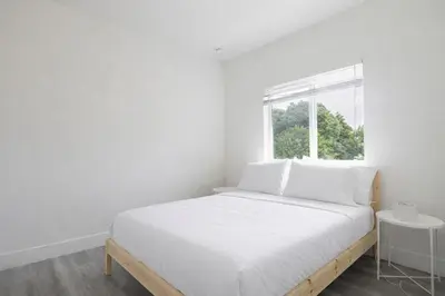 a white bedroom with a bed and a window at Comfortable 3BR Apartment, 4 Beds, Free Parking Included in Hallandale Beach