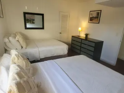 a bedroom with two beds and a dresser with a lamp at Hollywood Beach, Miami, Oceanfront retreat in Hollywood