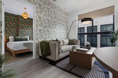 a living room with a couch and a bed at Voy House Wynwood with Rooftop Pool in Miami
