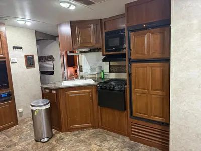 a small kitchen with wooden cabinets and a stove at Getsemany Inc RV Dreams Hollywood in Hollywood