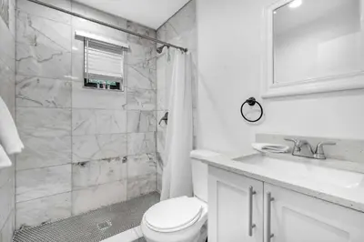 a white bathroom with a toilet and a shower at West Brickell #2 Renovated 2 2 Apt + Parking in Miami