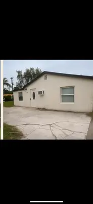 a white building with two windows and a driveway at Santorini Wynwood in Miami